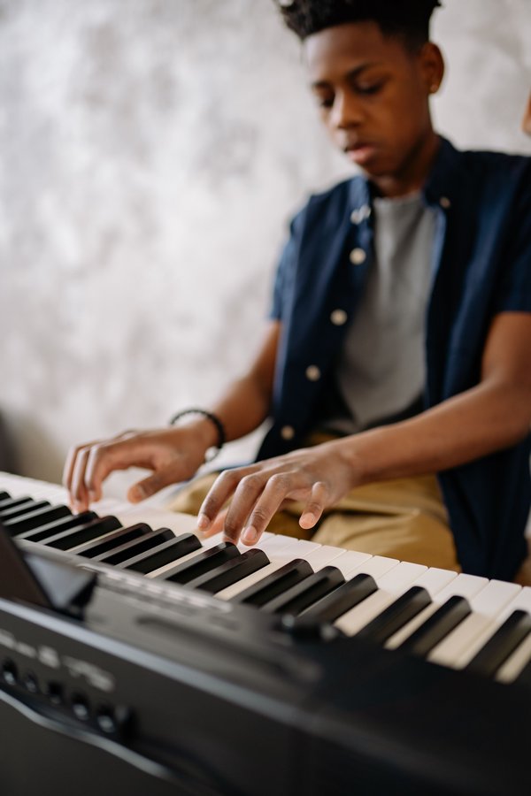 Young boy enthusiastically playing keyboard during a lesson