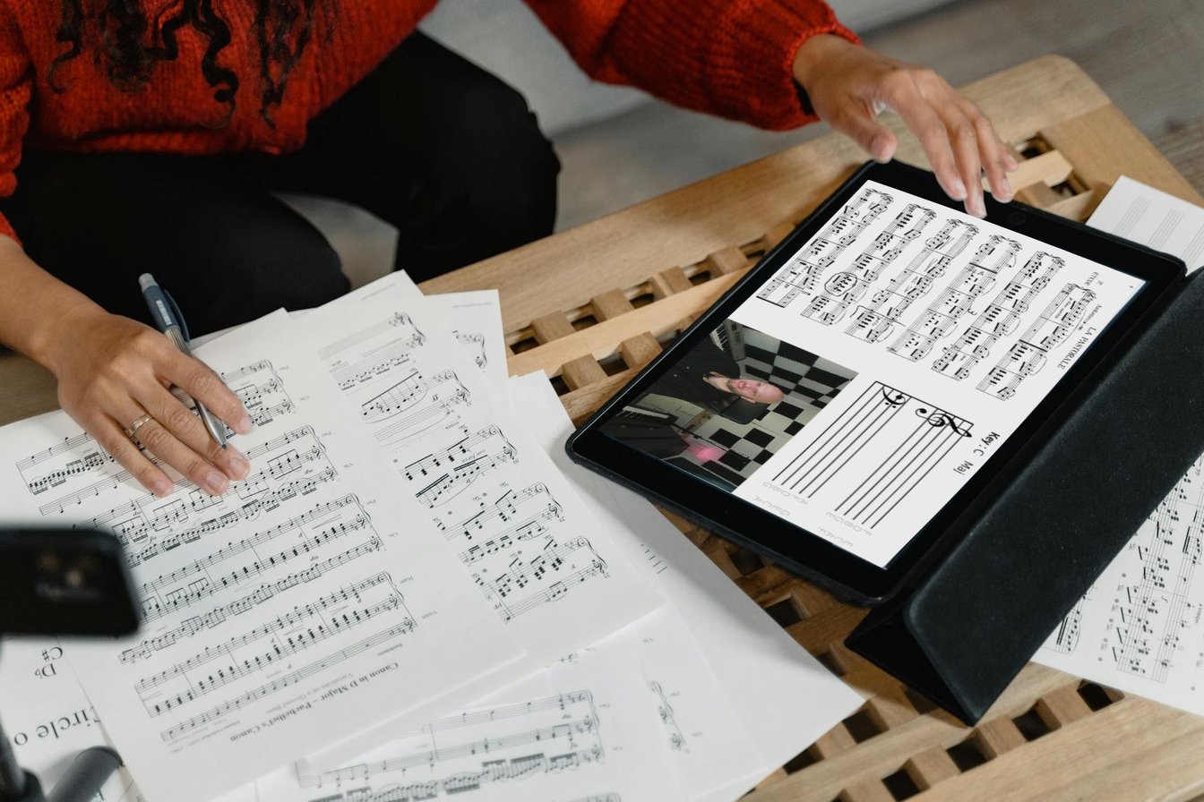 Sheet music and hands composing a piece on a table